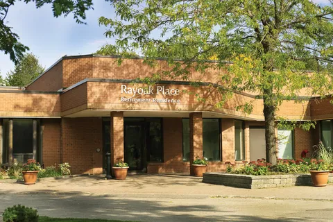 Brick front of Rayoak Place with windows, an entrance and planted beds.
