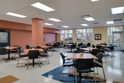 Dining room with tables, black chairs and large windows