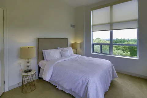 Bedroom with a double bed, bedside tables and a large window.
