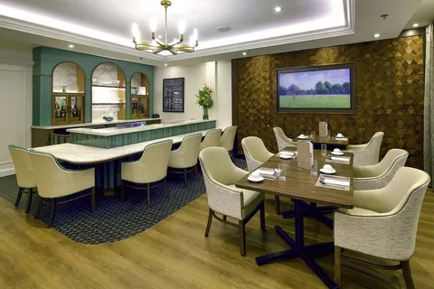 Pub with bar stools, tables, chairs and a television.