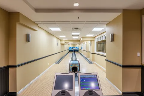 Two bowling lanes with scoring consoles at the front