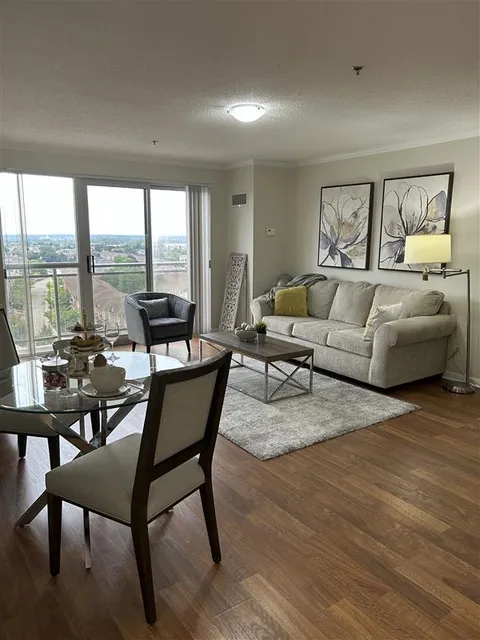 Sitting and dining area with a sofa, armchair and table beside windows