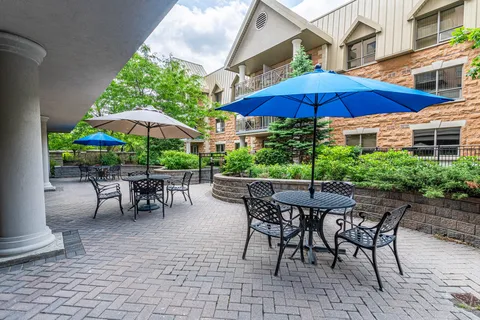 Paved patio with umbrella tables and chairs beside the residence