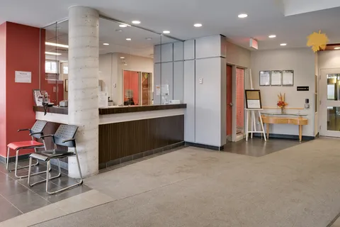 Reception counter with two chairs, glass partitions and a concrete column