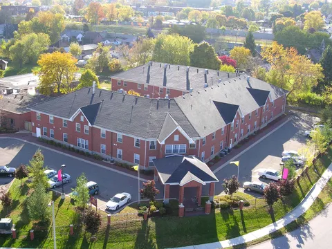 Aerial view of a two-storey brick building with a covered entrance and landscaped grounds