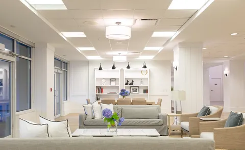 Common lounge with sofas, pendant lights and wide windows.
