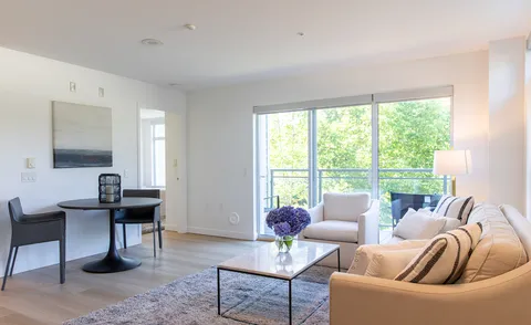 Suite living room with a sofa, armchairs and balcony doors.
