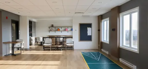 Room with a floor shuffleboard court, tables and chairs