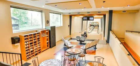 Bowling lanes with seating, scoring screens and shelves of shoes