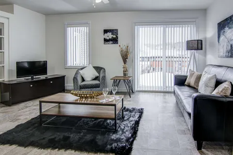 Suite living room with a sofa, coffee table and patio door.