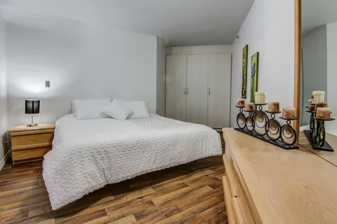 Bedroom with a double bed and wooden chest of drawers.