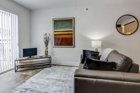 Suite sitting room with a sofa, television and patio door.