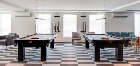 Billiards room with two pool tables and cue racks