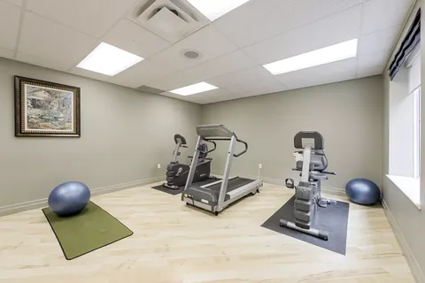 Exercise room with a treadmill, stationary bikes and exercise balls