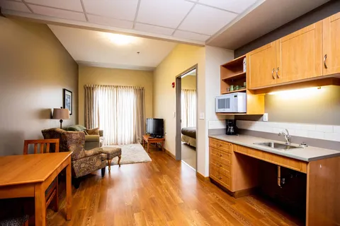 Kitchenette with wooden cabinets, a table and upholstered seating