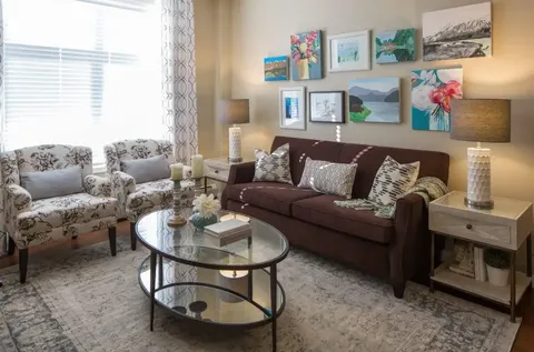 Sitting area with a sofa, armchairs and landscape paintings