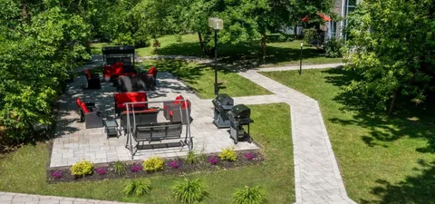 Garden patio with covered swings, red chairs and a barbecue