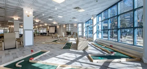 Indoor putting lanes beside large windows and seating