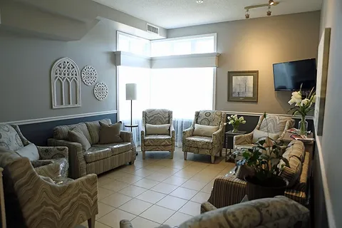 Room with sofas, armchairs, a television and large windows
