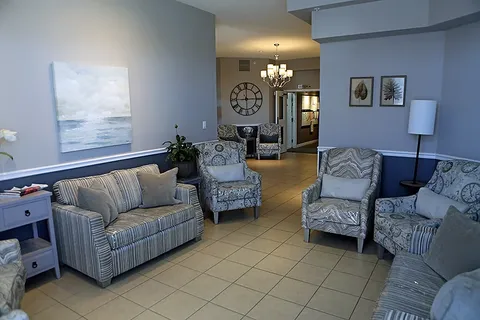 Room with sofas and armchairs beside large windows