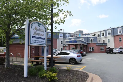 Melville Gardens building and entrance sign beside the parking area.