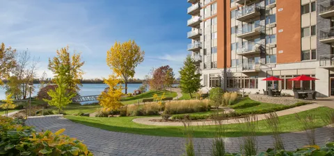 Garden paths and patio seating beside the residence overlooking a river