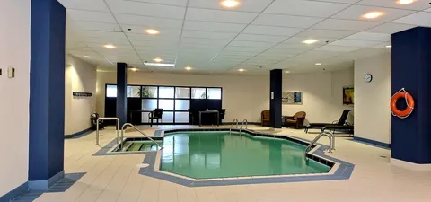Indoor swimming pool with tiled decking and lounge seating.