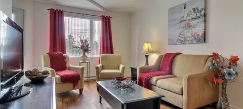 Suite living area with armchairs, sofa and a window.