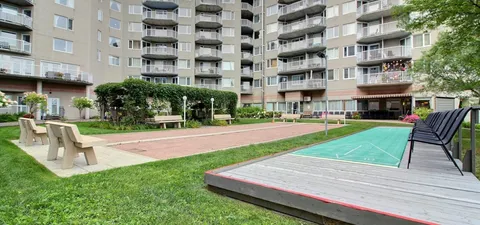 Outdoor game courts and benches beside the residence.