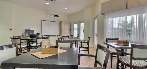 Games room with tables, chairs and a projection screen.