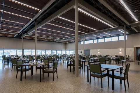 Spacious dining room with tables, chairs and high exposed ceiling beams