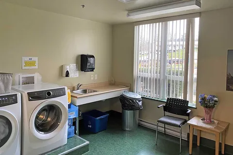 Laundry room with front-loading machines, a sink and folding counter.