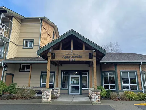 Assisted-living entrance with a timber canopy and glass doors.