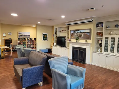 Lounge with blue armchairs, a fireplace and built-in shelves.