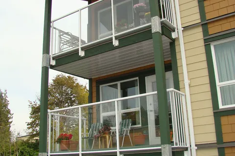 Residence balconies with white railings and timber-framed supports.