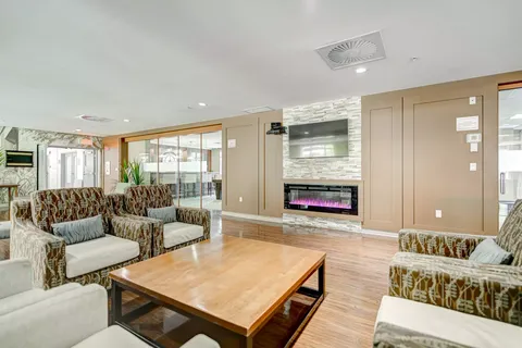 Patterned sofas and armchairs beside a fireplace and wall-mounted television