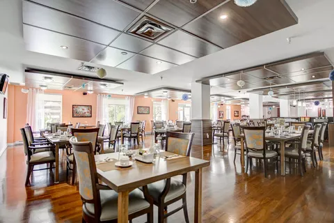 Dining room with set tables, upholstered chairs and mirrored columns