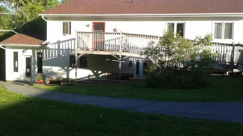 Side exterior with an elevated deck and access ramp.