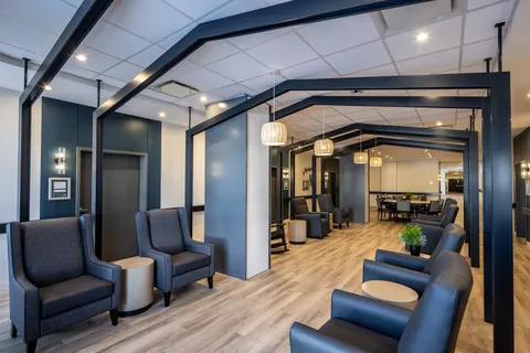 Room with rows of armchairs beneath dark ceiling beams