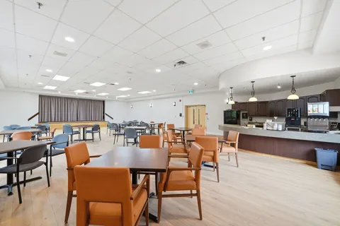 Dining area with tables, chairs and a counter along the wall.