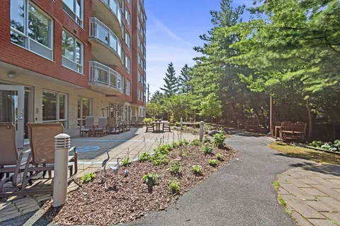 Garden path and patio with outdoor chairs, benches and trees