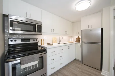 Suite kitchen with white cabinets and appliances