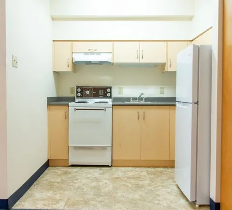 Kitchen with a stove, refrigerator, sink and cupboards
