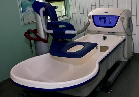 Bathing tub with a lift chair beside a window