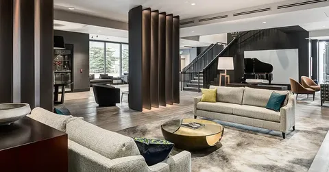 Seating area with sofas, a piano and a staircase