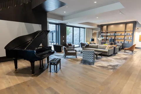 Room with a grand piano, sofas and bookshelves