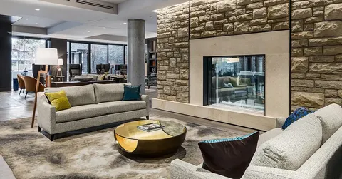 Sofas beside a stone fireplace wall and round coffee table