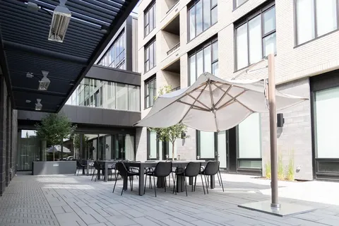 Covered patio with tables, chairs and a large umbrella