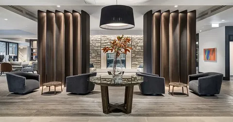 Seating area around a glass table beside dark columns