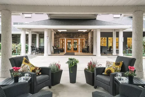 Covered entrance beside wicker chairs and potted flowers